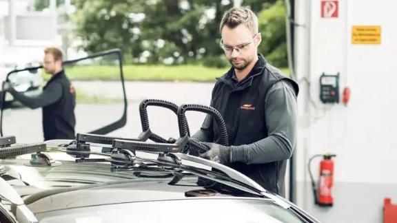 Carglass Mitarbeiter fügt neue Dachscheibe im Fahrzeug ein